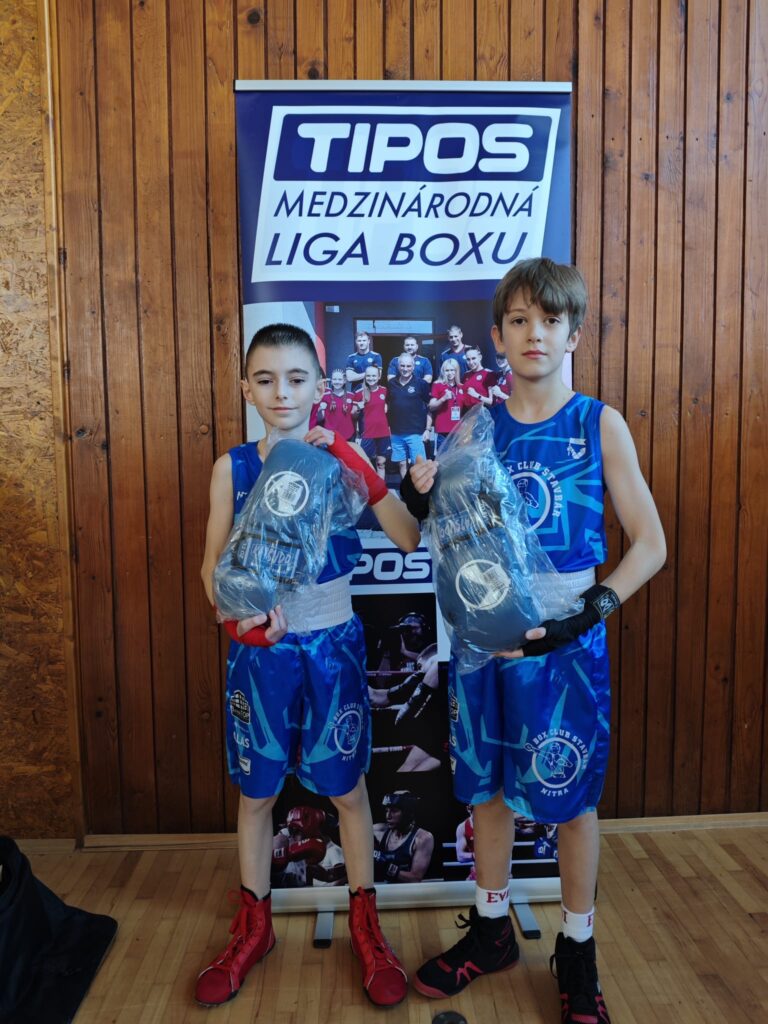 Dvaja boxeri Box Clubu Stavbár Nitra v ringových dresoch s cenami